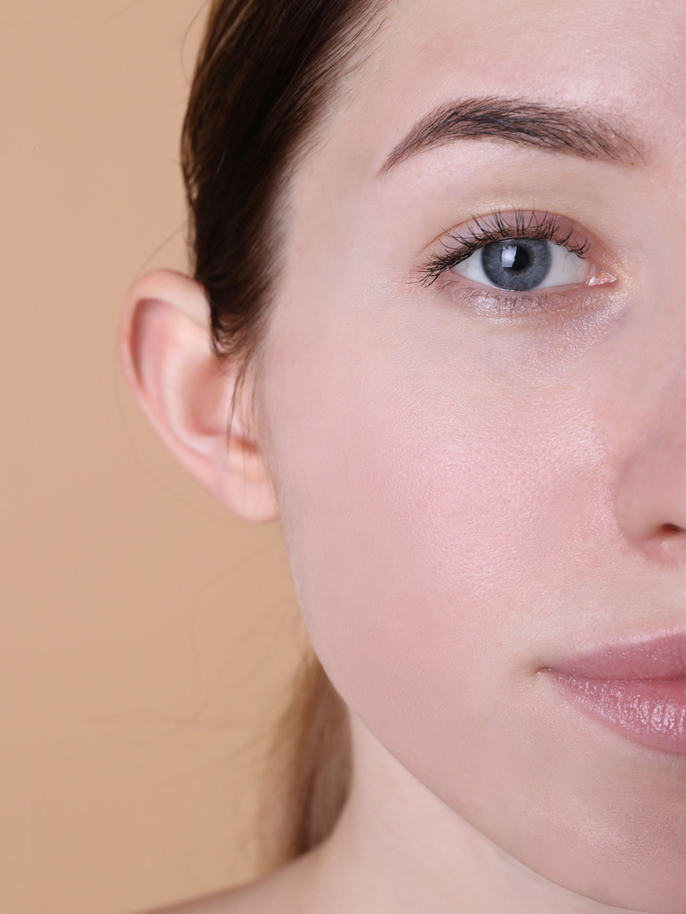 A woman's face with clear skin, showing improved complexion after microneedling treatment