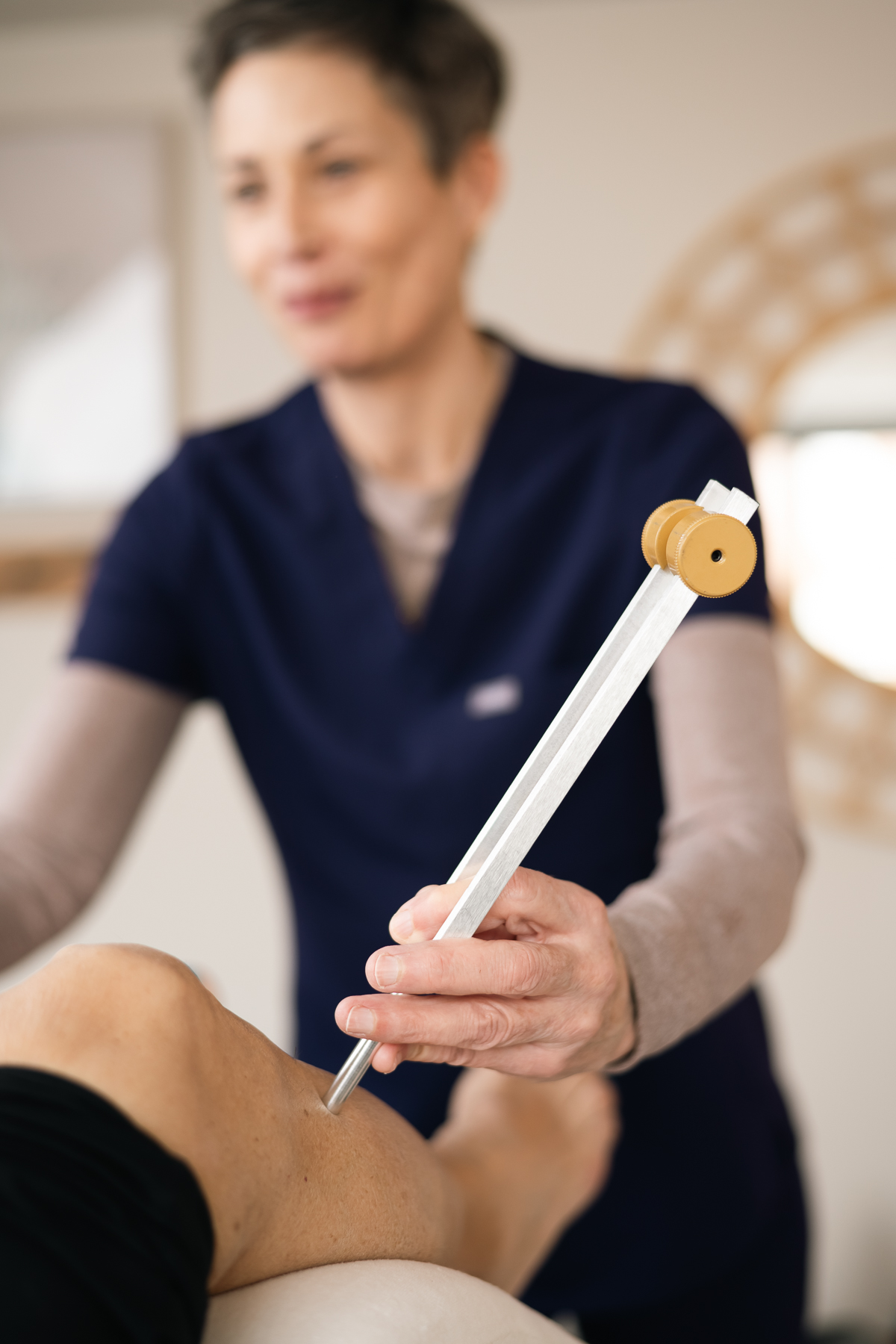 Tuning fork therapy being applied to a patient’s knee for targeted treatment