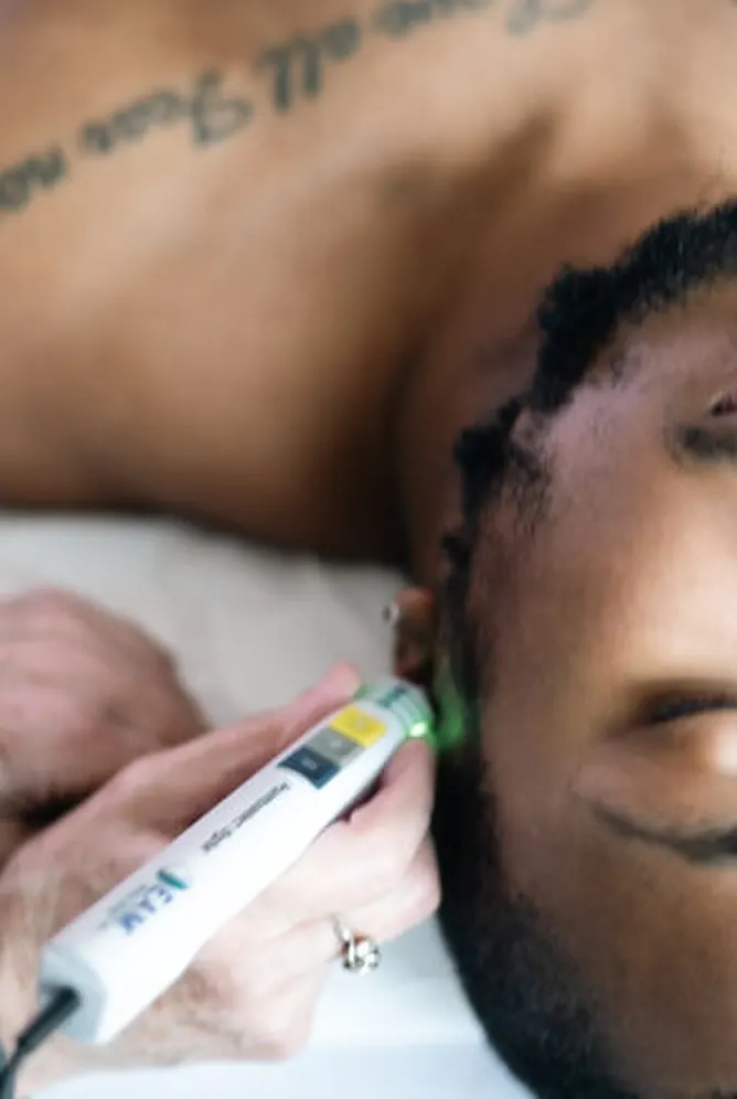 Dana Scarton, L.Ac., treating auricular and vagus-nerve points at a patient's ear
