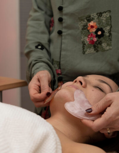 Gua sha facial massage, using rose quartz gua sha tools to gently sculpt the face