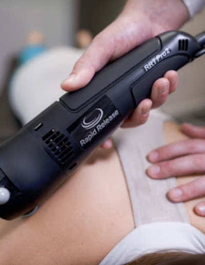 A rapid release therapy device being used on a person's upper back during a treatment session