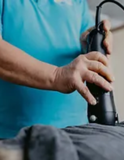 A therapist performing a Rapid Release Therapy session using a handheld device on a client's back