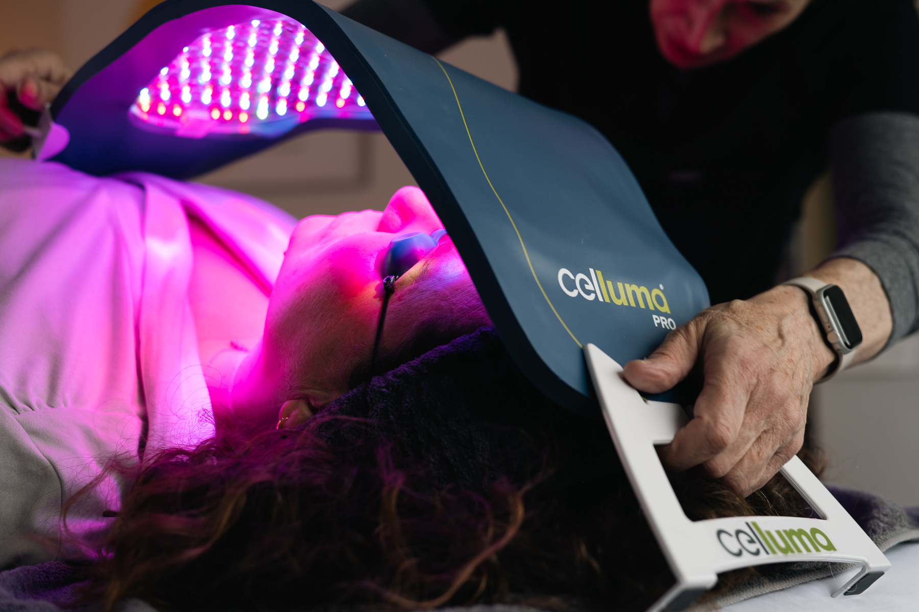 Patient undergoing LED light therapy with a Celluma PRO device for skin treatment